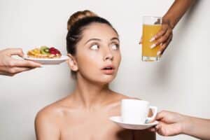 femme qui hésite et regarde des aliments