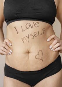 ventre de femme post partum avec écrit dessus "I love myself"