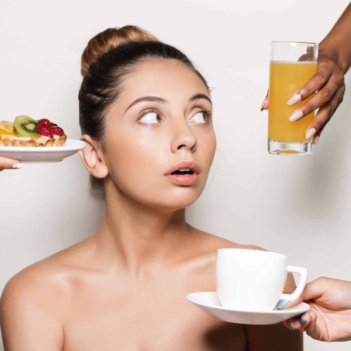 femme qui hésite et regarde des aliments