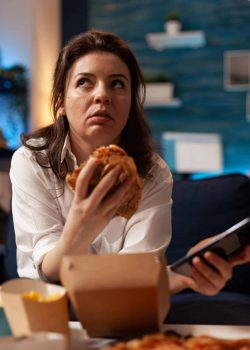 Femme qui mange du fast food et etant triste
