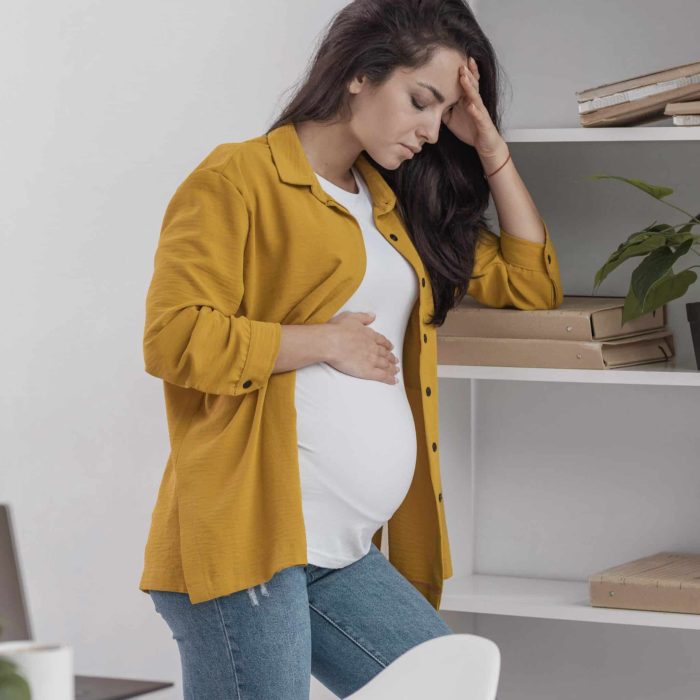 femme enceinte triste une mains sur la tête